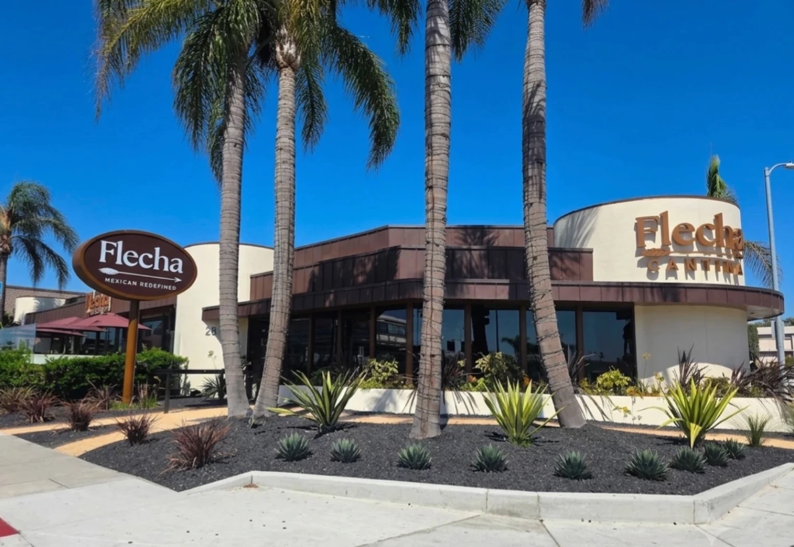 Flecha Cantina Newport Beach on a sunny day, framed by palms
