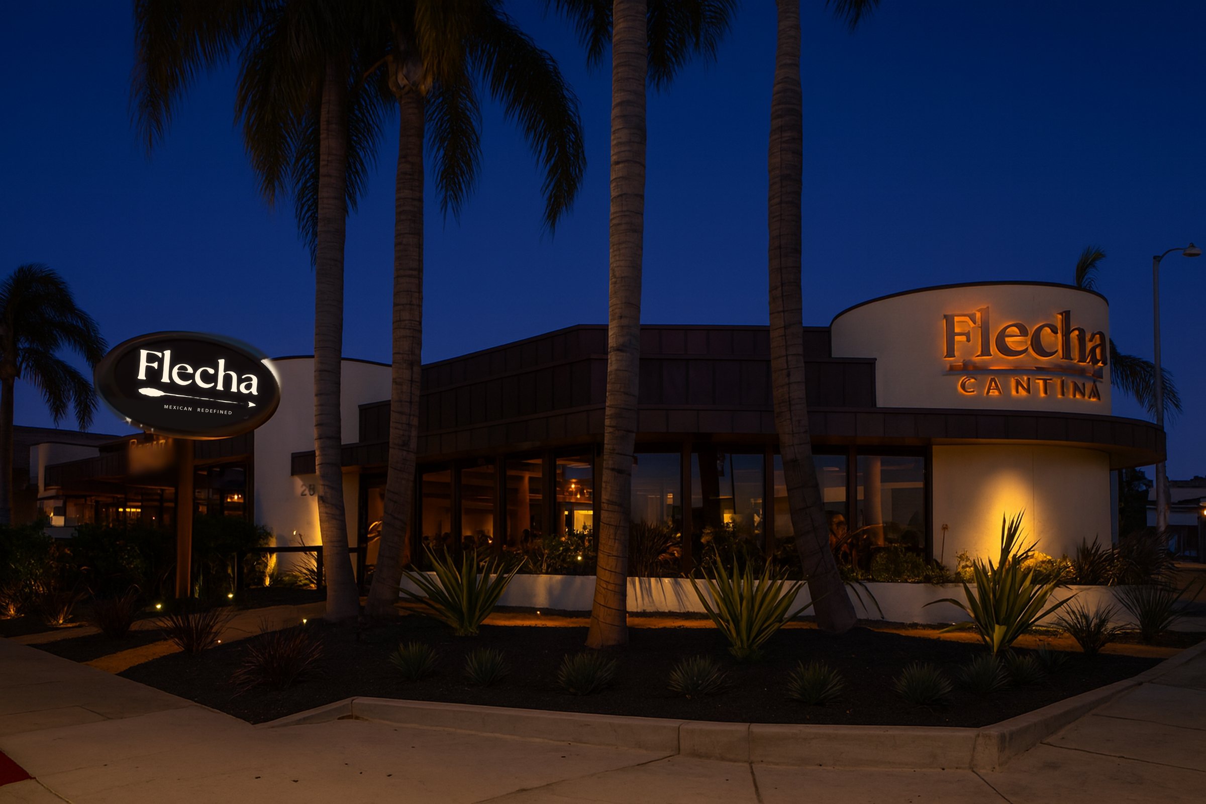 Flecha Cantina Newport Beach at dusk, its signs and windows glowing beneath the palms